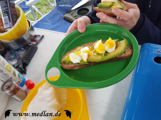 Frühstück: Pochiertes Ei auf Avocado und getoastetem Brot